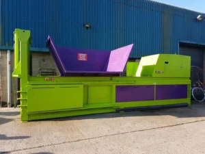 The CB65X baler installed at Numatic International. The baler is outside and is purple and green.