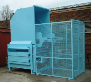 A blue static compactor with a cage.